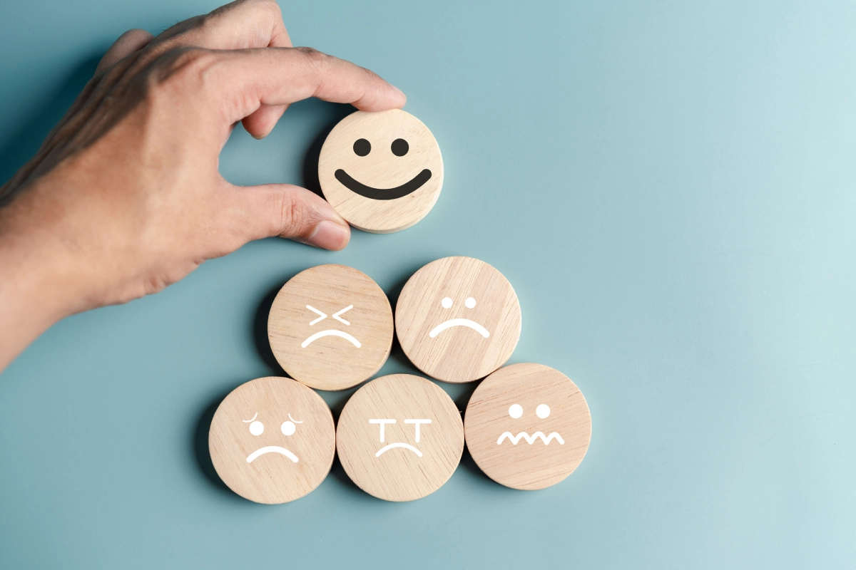 Detalhe de representações gráficas de estados de humor em madeira