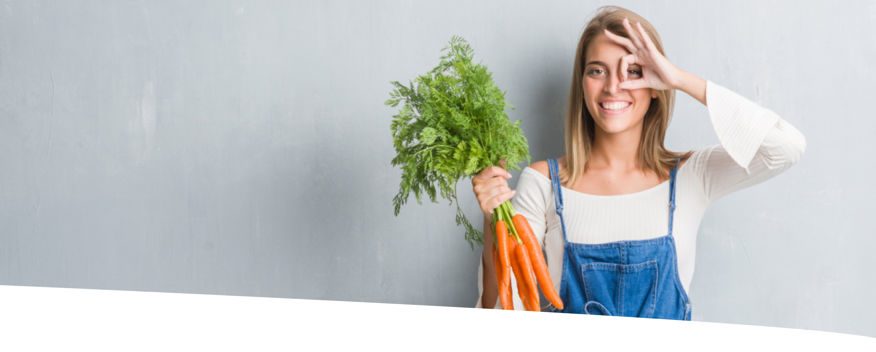 Mulher segurando cenouras pelo talo e destacando o olho com os dedos da outra mão