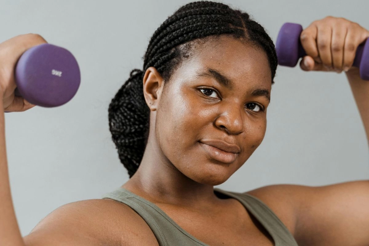 Mulher segurando e levantando pesos de academia
