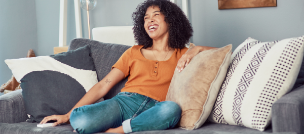 Mulher sentada no sofá de casa sorridente e com aparência saudável