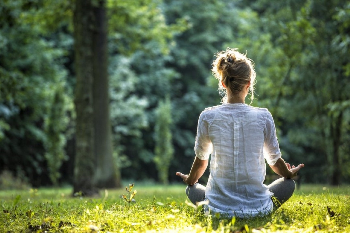 Pessoa meditando ao ar livre em meio à natureza, praticando uma técnica eficaz para reduzir o estresse e melhorar o bem-estar mental.