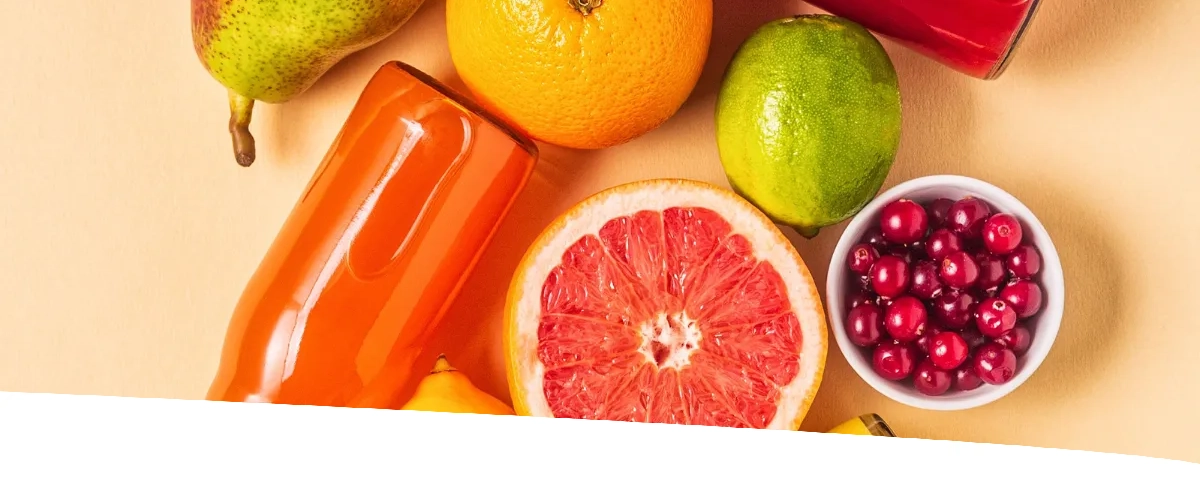 Detalhe de diversos alimentos dispostos sobre a mesa de maneira harmoniosa. Entre eles: mel, frutas, castanhas...